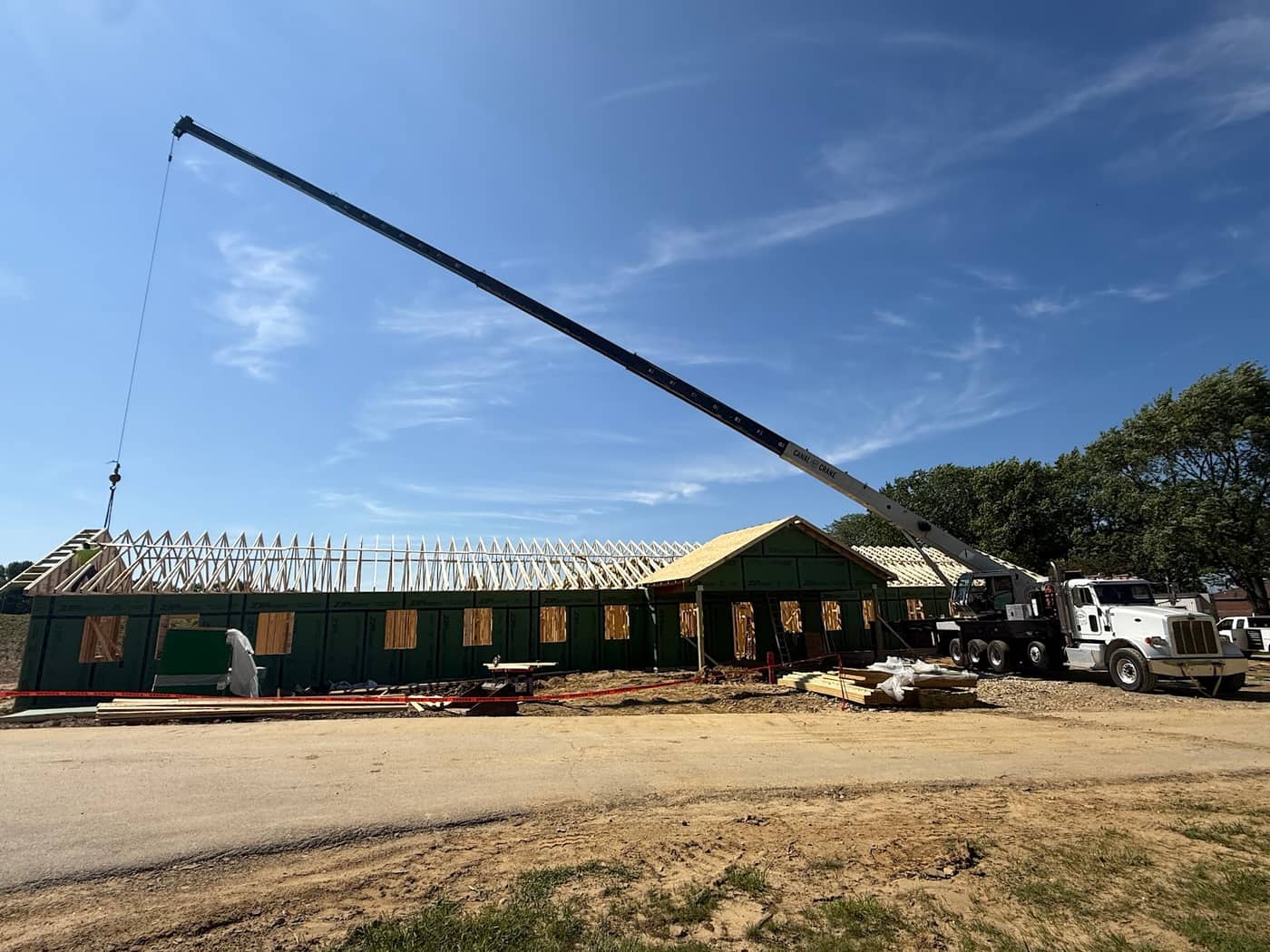 Canal Crane boom truck setting roof trusses on a construction site in Northeast Ohio